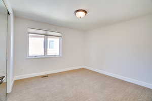 Carpeted empty room with baseboards