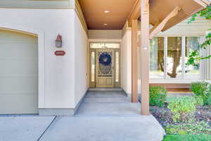 Doorway to property with stucco siding and a garage