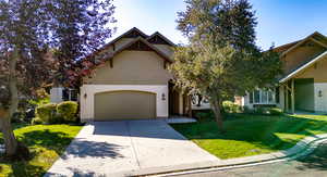 View of front of house featuring concrete driveway and a front lawn
