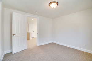 Spare room with light carpet and baseboards