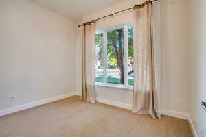 Empty room with light carpet and baseboards