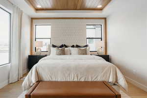 Bedroom with wood finished floors, wood ceiling, recessed lighting, and a raised ceiling