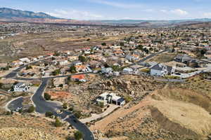 Aerial view of property's location featuring a mountainous background and nearby suburban area