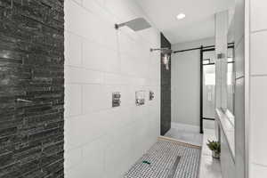 Full bathroom with a tile shower, light tile patterned floors, and recessed lighting