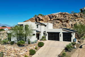 Contemporary home with a garage, stucco siding, a mountain view, concrete driveway, and a standing seam roof