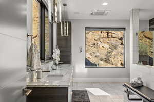 Bathroom featuring double vanity, recessed lighting, and light tile patterned flooring