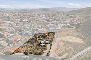 Aerial view of property and surrounding area with a mountainous background and nearby suburban area