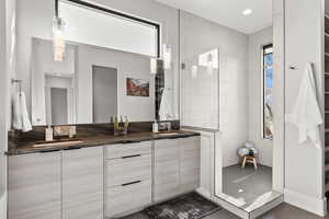 Full bathroom with double vanity, a walk in shower, and recessed lighting