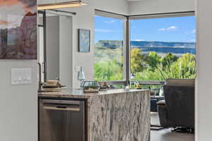 Kitchen with stainless steel dishwasher and dark stone countertops