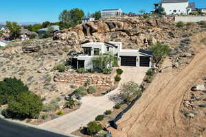 View of front of house with concrete driveway, stucco siding, an attached garage, and a residential view