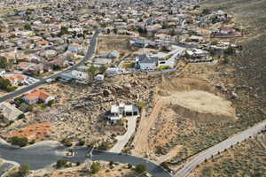 Aerial view of property and surrounding area featuring nearby suburban area