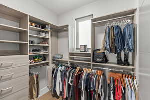 Walk in closet with light wood finished floors