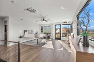 Living room featuring cooling unit, wood-type flooring, and a ceiling fan