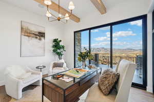 Office featuring a mountain view, beamed ceiling, light wood-style flooring, and a chandelier