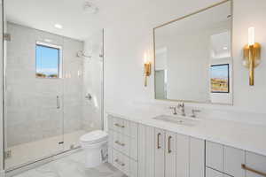 Bathroom featuring vanity, a shower stall, plenty of natural light, light marble finish flooring, and recessed lighting