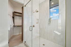 Full bath featuring a stall shower, light carpet, and a closet