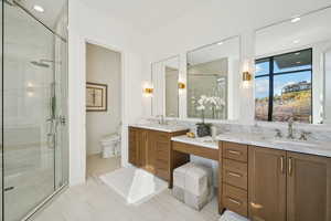 Full bathroom with a stall shower, two vanities, and recessed lighting