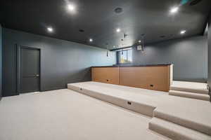 Carpeted home theater room with recessed lighting