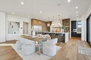 Dining area with light wood-style floors and recessed lighting