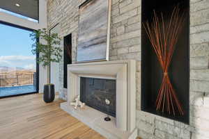 Unfurnished living room with a glass covered fireplace, wood finished floors, and a mountain view