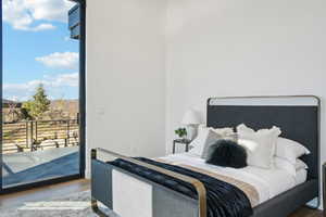 Bedroom with wood finished floors and access to outside