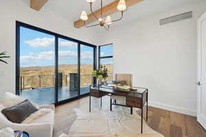 Home office featuring beamed ceiling, wood-type flooring, and a chandelier