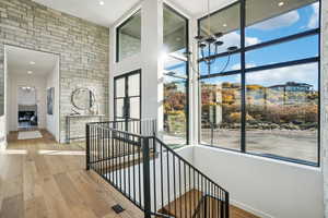 Stairway featuring a chandelier, wood finished floors, a fireplace, recessed lighting, and a towering ceiling