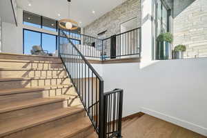 Stairway with wood finished floors and recessed lighting