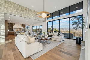 Living room featuring recessed lighting, wood finished floors, a towering ceiling, a chandelier, and a mountain view