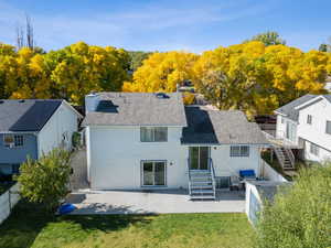 Back of property featuring a patio, a fenced backyard, roof with shingles, and a chimney