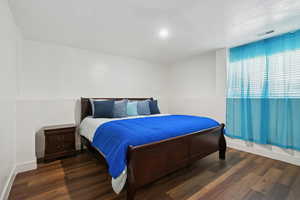 Bedroom with dark wood-style floors and a textured ceiling