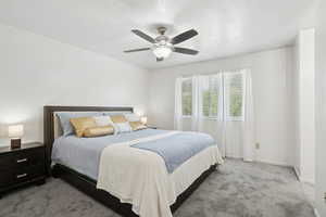 Bedroom featuring carpet, ceiling fan, and a textured ceiling