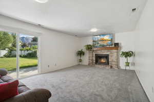 Carpeted living area featuring a brick fireplace and a textured ceiling