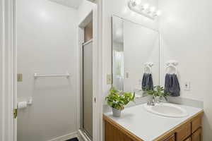 Full bath featuring a stall shower and vanity