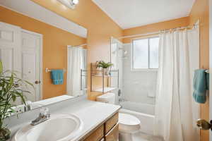 Bathroom featuring shower / bath combo with shower curtain and vanity