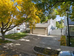 View of front of property with brick siding, driveway, a gate, and an attached garage