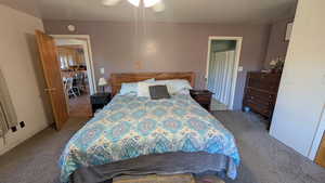 Carpeted bedroom featuring a ceiling fan