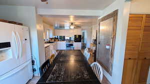 Kitchen featuring white appliances, white cabinetry, ceiling fan, light countertops, and light tile patterned flooring