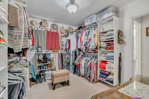 Spacious closet with light colored carpet