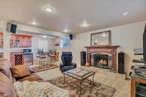 Basement Apartment Living area with light carpet, a fireplace, recessed lighting, and bar area
