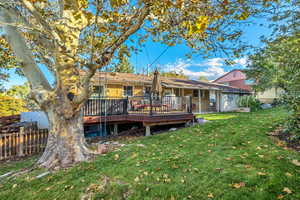 Rear view of property featuring a deck and brick siding