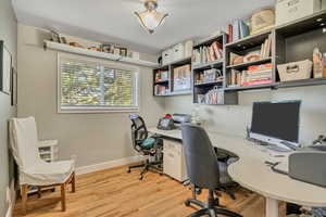 Office area featuring light wood-style flooring and baseboards