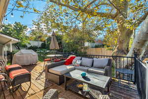 Deck with an outdoor hangout area, outdoor dining space, a fenced backyard, and grilling area