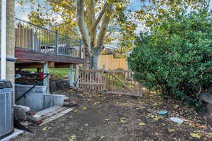 View of yard featuring a deck and a gate