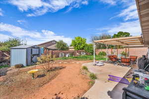 Fenced backyard with a pergola, a storage unit, a patio area, and outdoor dining space