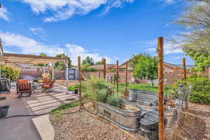 Fenced backyard with a storage shed, a patio, a garden, and a pergola