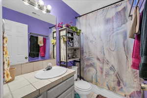 Bathroom with vanity, shower / bath combination with curtain, and tile patterned flooring