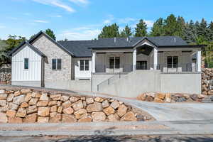 View of front of property featuring stone siding and board and batten siding