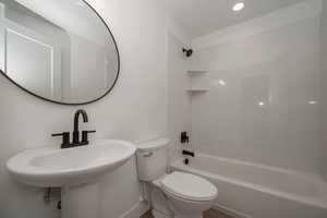 Bathroom with shower / washtub combination and recessed lighting