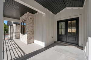 Doorway to property with stone siding and board and batten siding